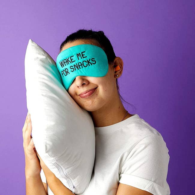 A person wearing the eye mask that reads, 