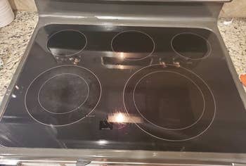 the same stovetop now looking clean after using the cleaning kit