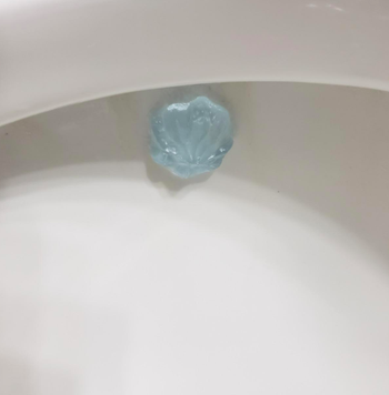 Reviewer's picture of the cleaning gel attached to the side of their toilet 