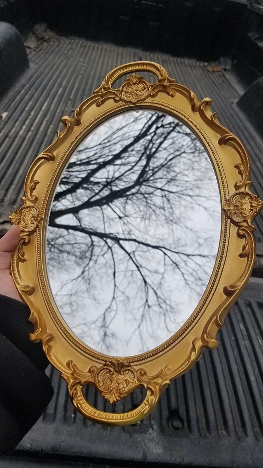 image of reviewer holding the gold decorative mirror up