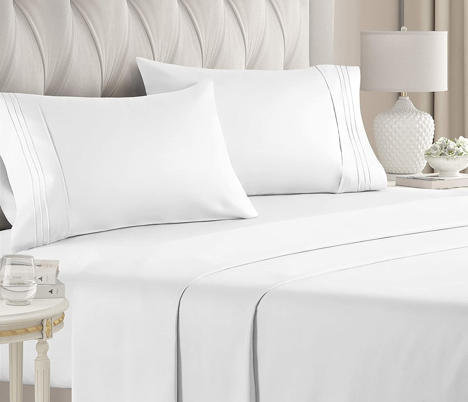 White bed sheets on a bed with matching pillows