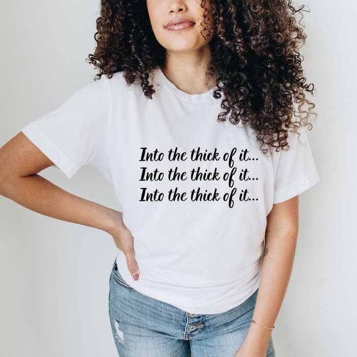 a model wearing a white tee that says &quot;into the thick of it&quot;