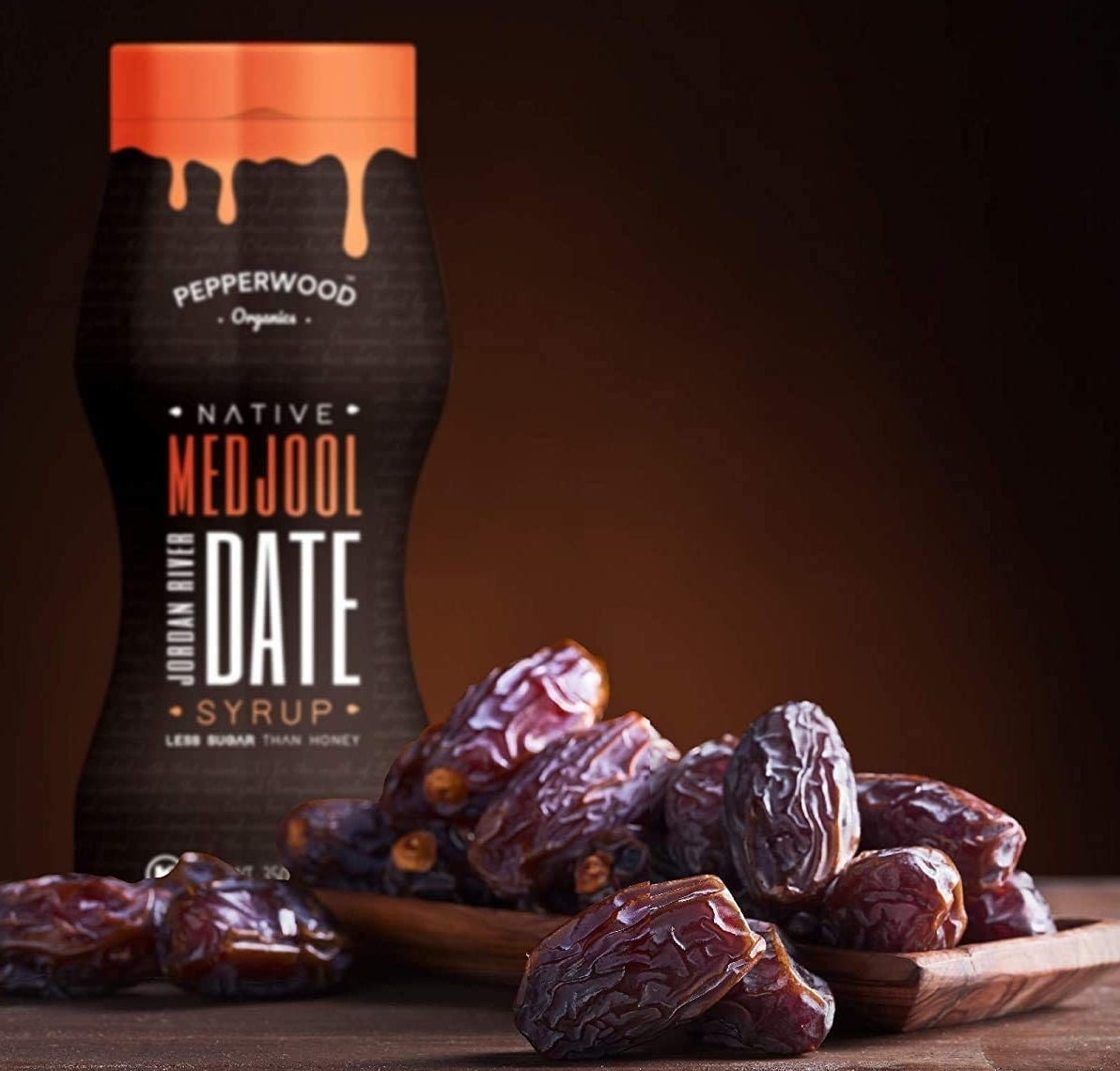 The bottle of syrup behind a pile of dates
