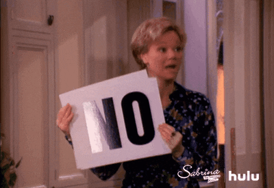 Zelda segurando cartaz que diz "NÃO" em "Sabrina, Aprendiz de Feiticeira"