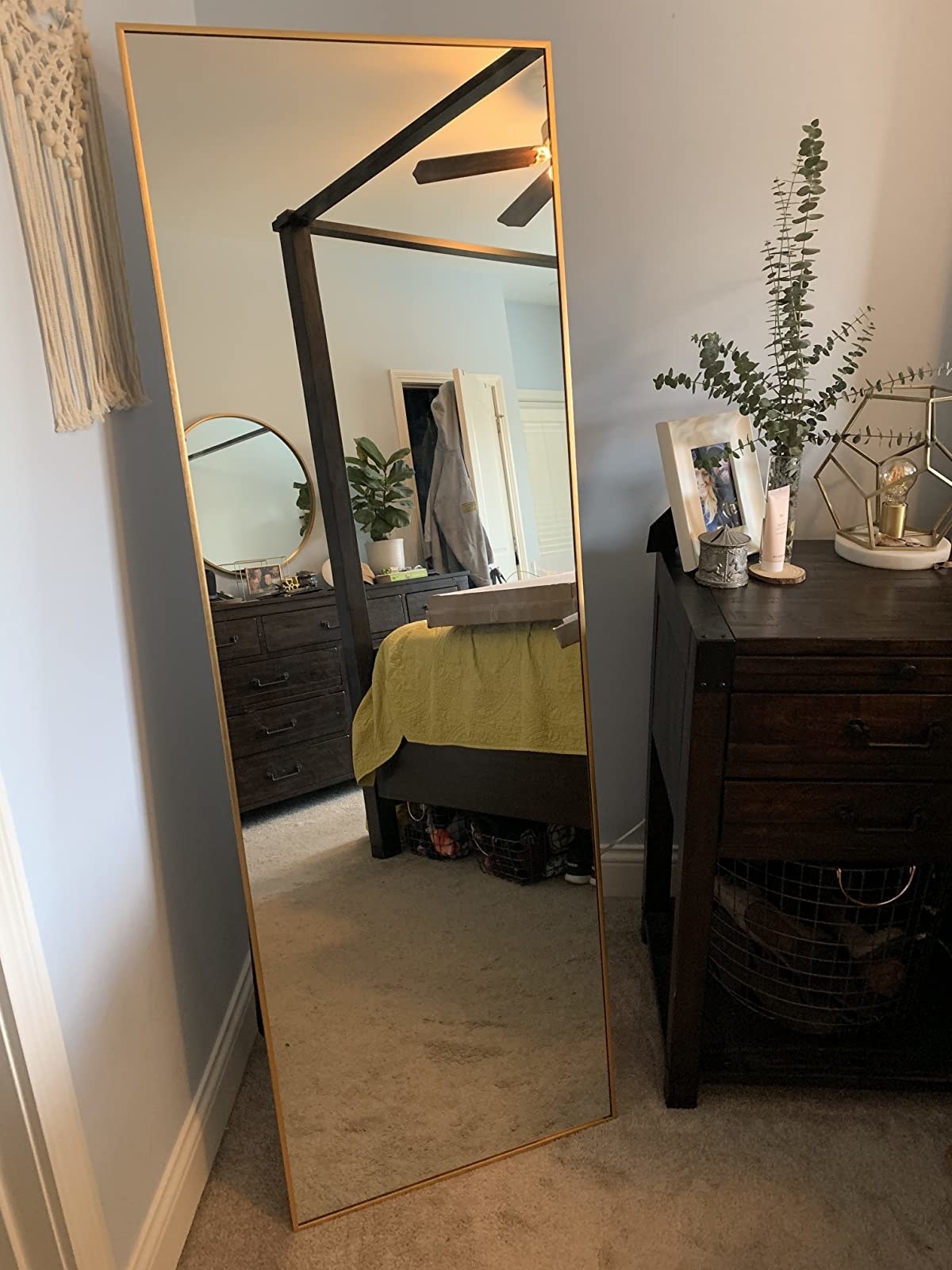 gold framed mirror that&#x27;s standing up on carpet