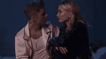 A GIF of Hailey Bieber and Justin Bieber from his music video looking at each other while being very in love
