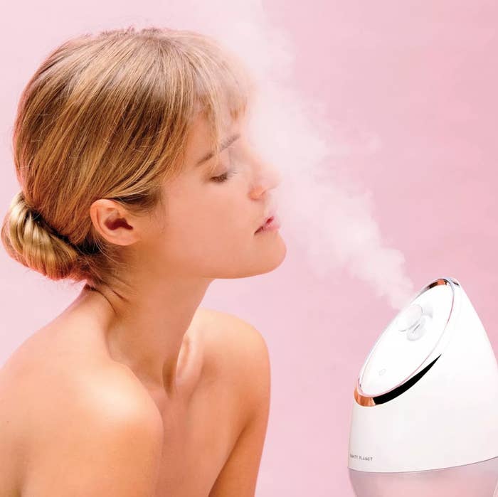 woman with vanity planet facial steamer blowing steam in her face