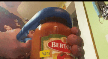 GIF of reviewer opening sauce jar with the jar opener