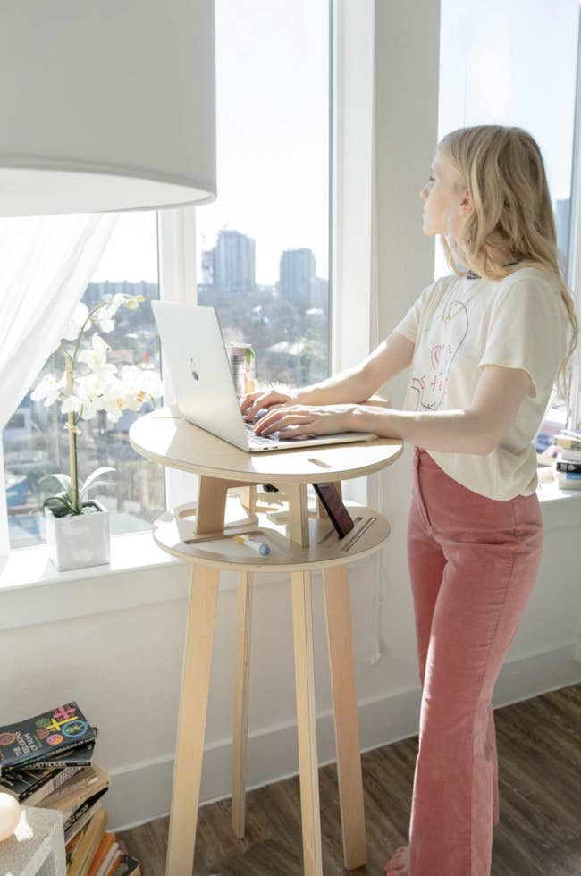 model standing at the small standing desk