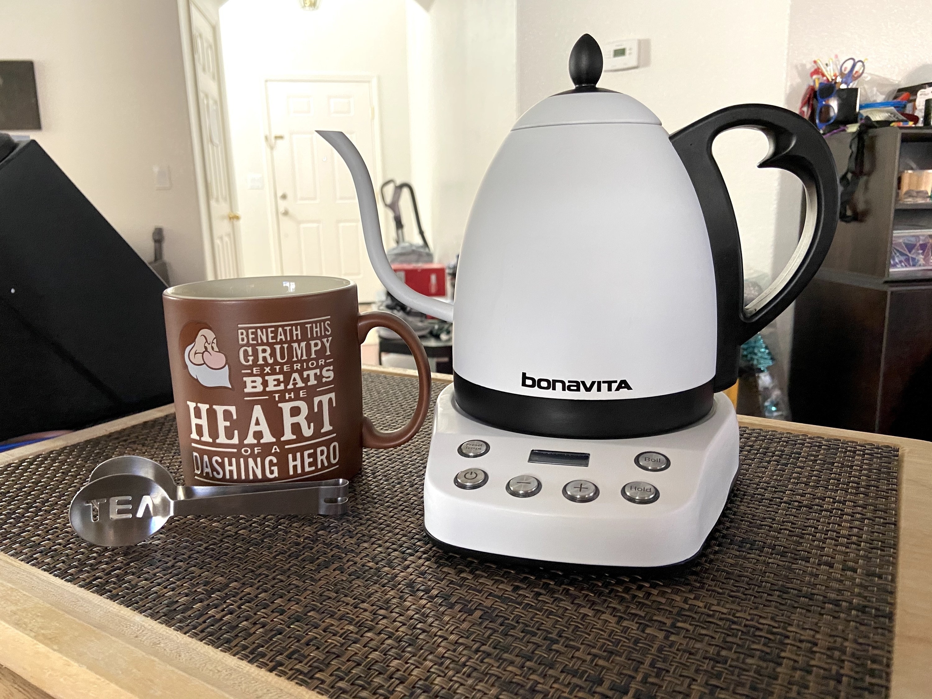 The electric kettle on a counter in white.