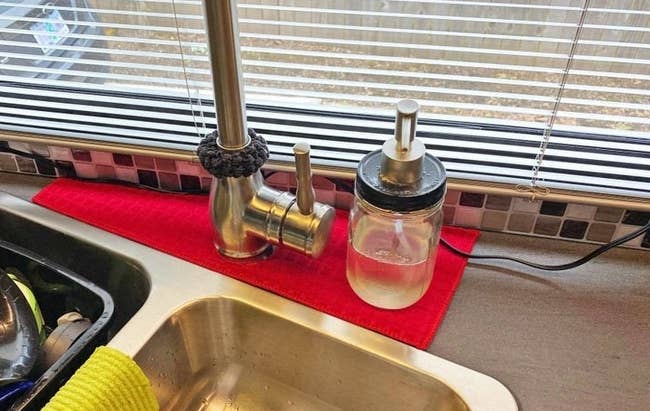 Red drip catcher placed around kitchen sink's faucet