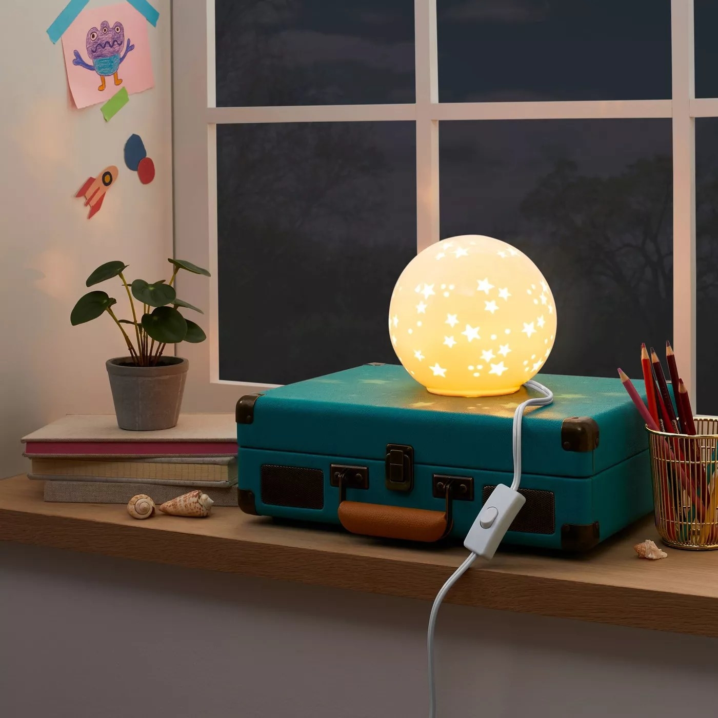 The nightlight with a star pattern illuminated in a child&#x27;s room