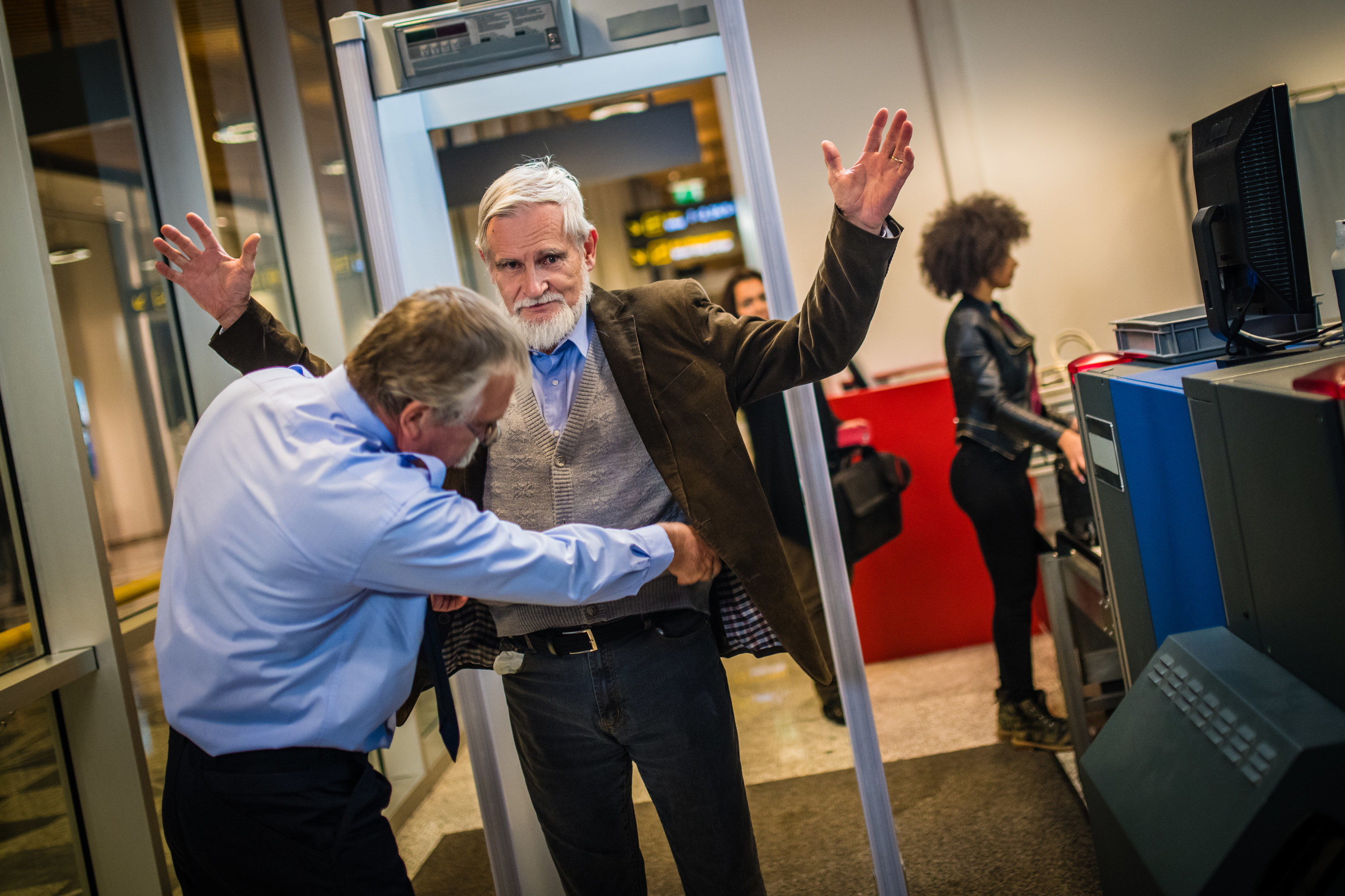 Man at airport getting patted down by airport secuirty