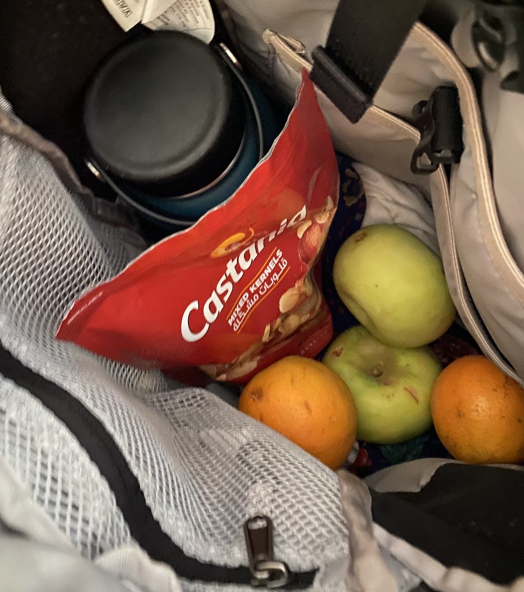 Backpack with a water bottle, nuts, and fruit