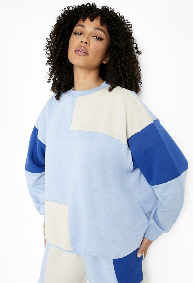 the model wearing the geometric crew neck sweater with a baby blue base and cobalt and white blocks