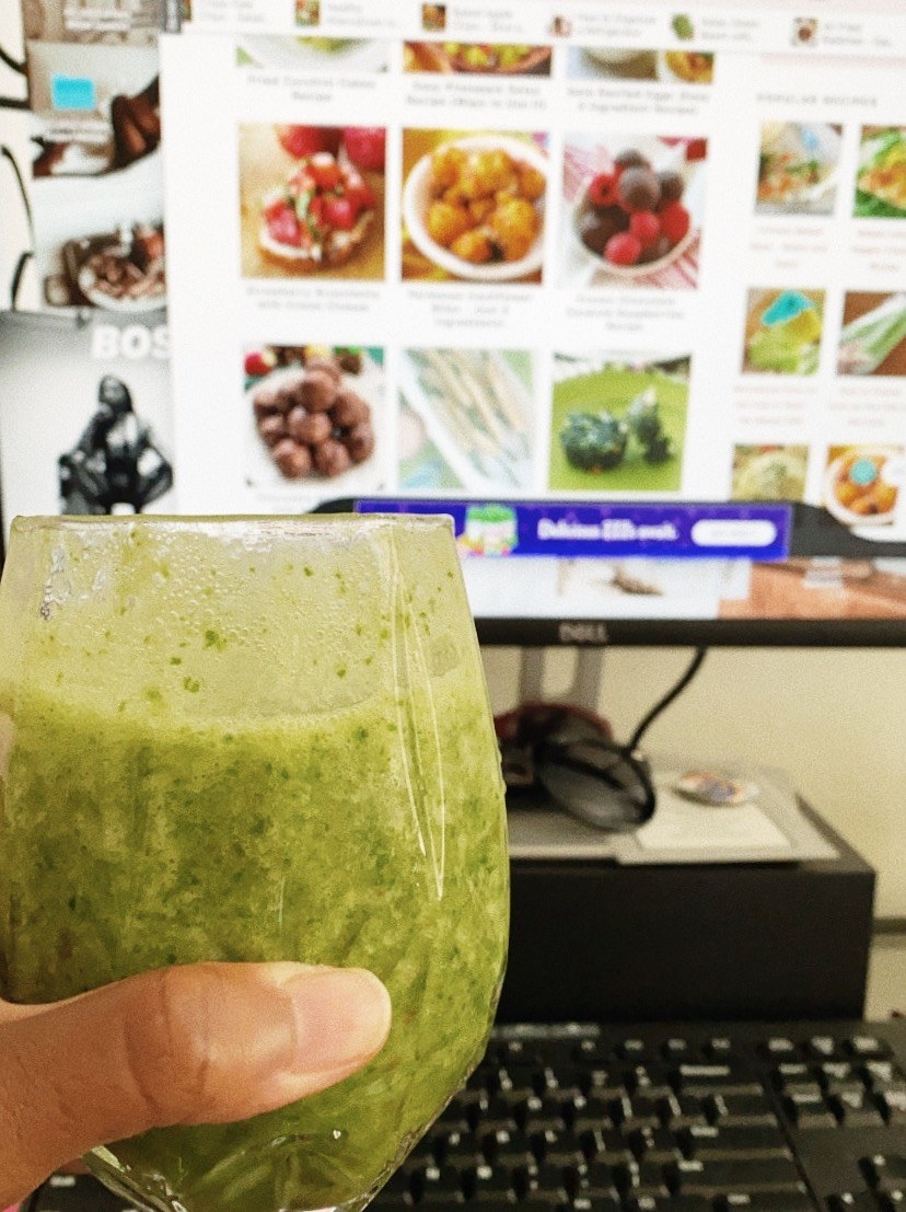 The author holding a green smoothie