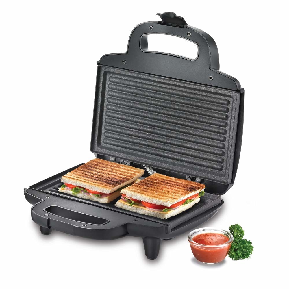 Electric sandwich maker with 2 perfectly grilled sandwiches on it with checkup