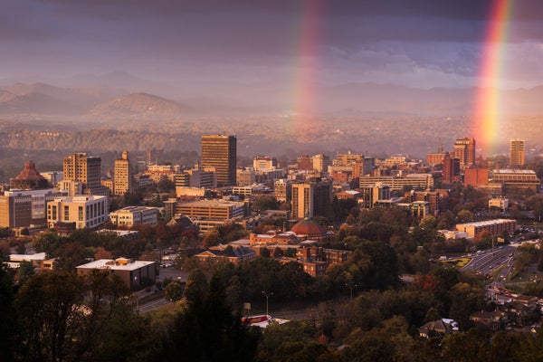 The Asheville skyline with mountains in the background and rainbows.