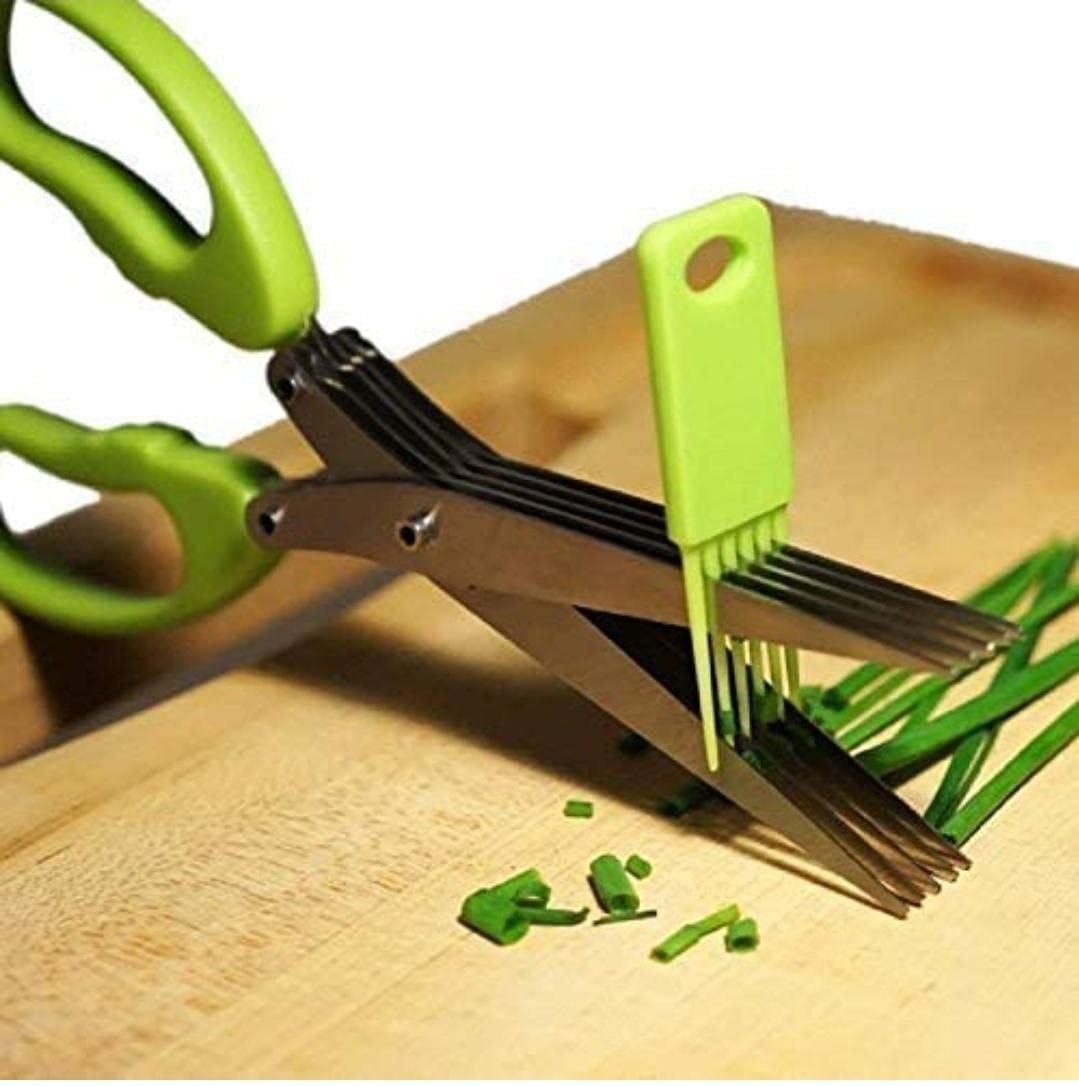 A pair of scissors cutting spring onion greens.