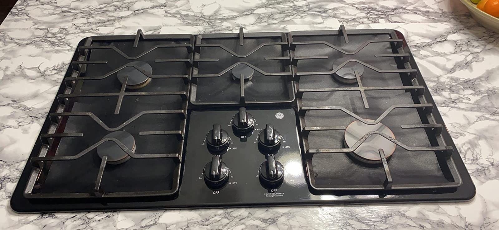 reviewer&#x27;s stove with the black covers around the burners