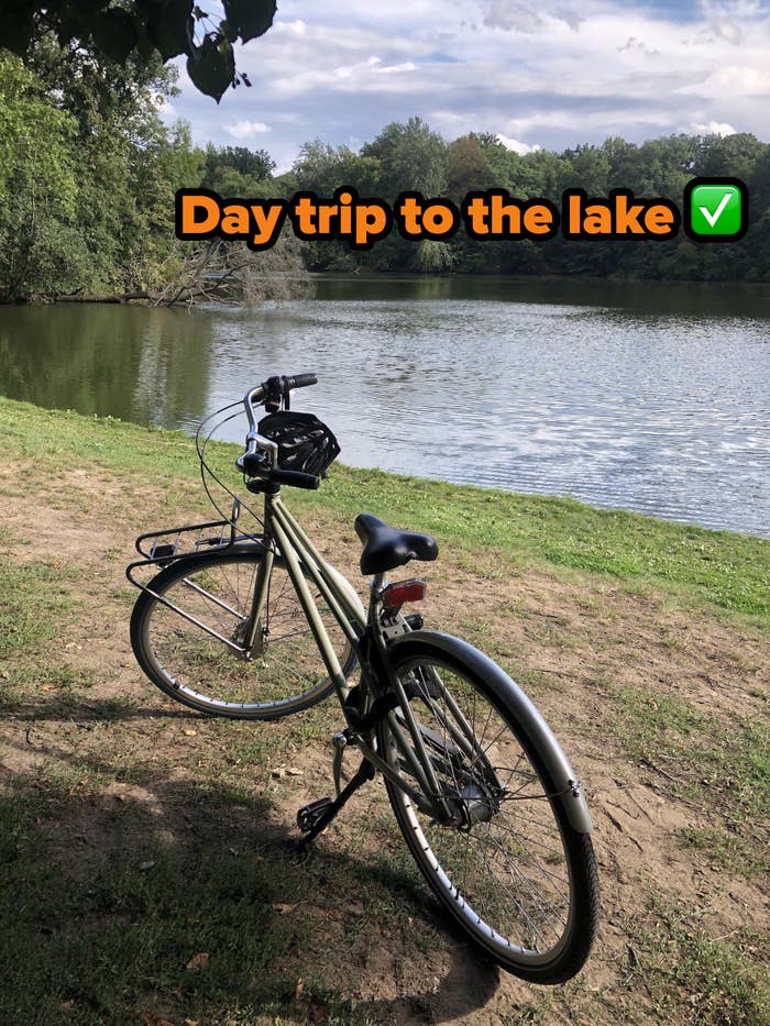 Writer&#x27;s bike parked right next to a lake, with text reading, &quot;Day trip to the lake, check&quot;