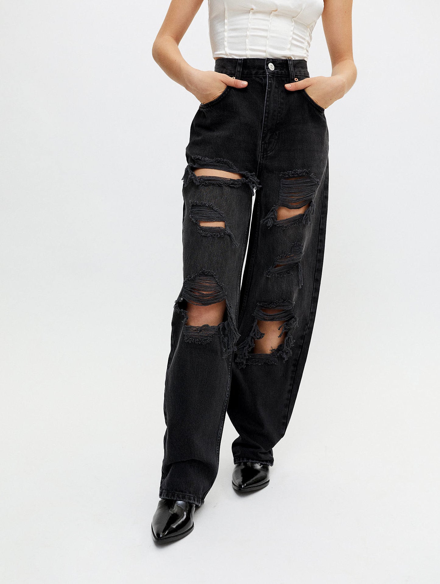 a person wearing the ripped baggy jeans on a white background