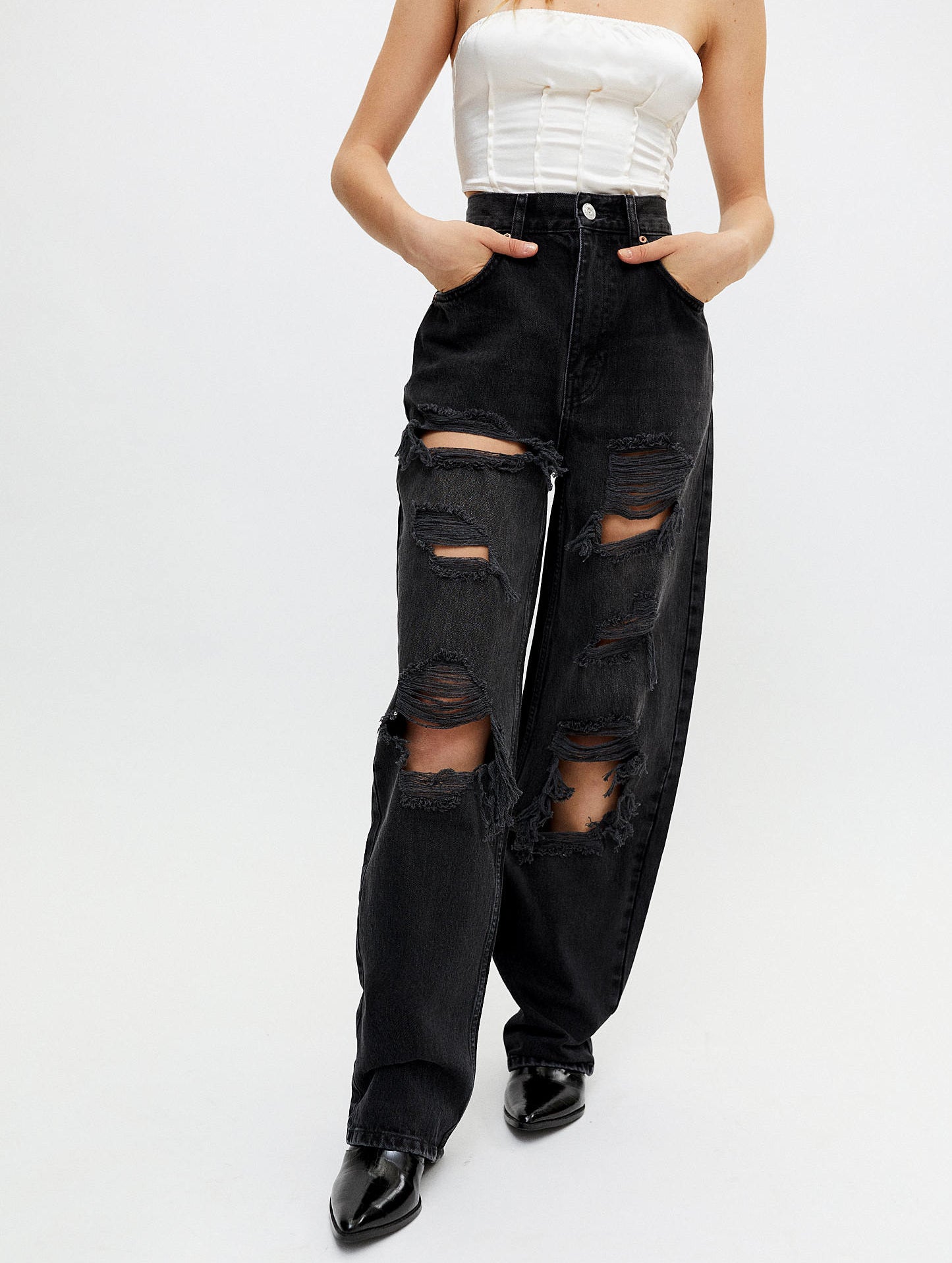 a person wearing the ripped baggy jeans on a white background