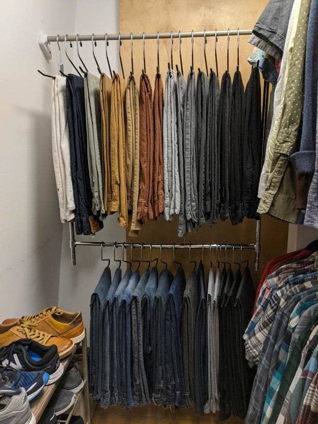 reviewer&#x27;s closet with pants hung on the top and bottom of the adjustable closet rod