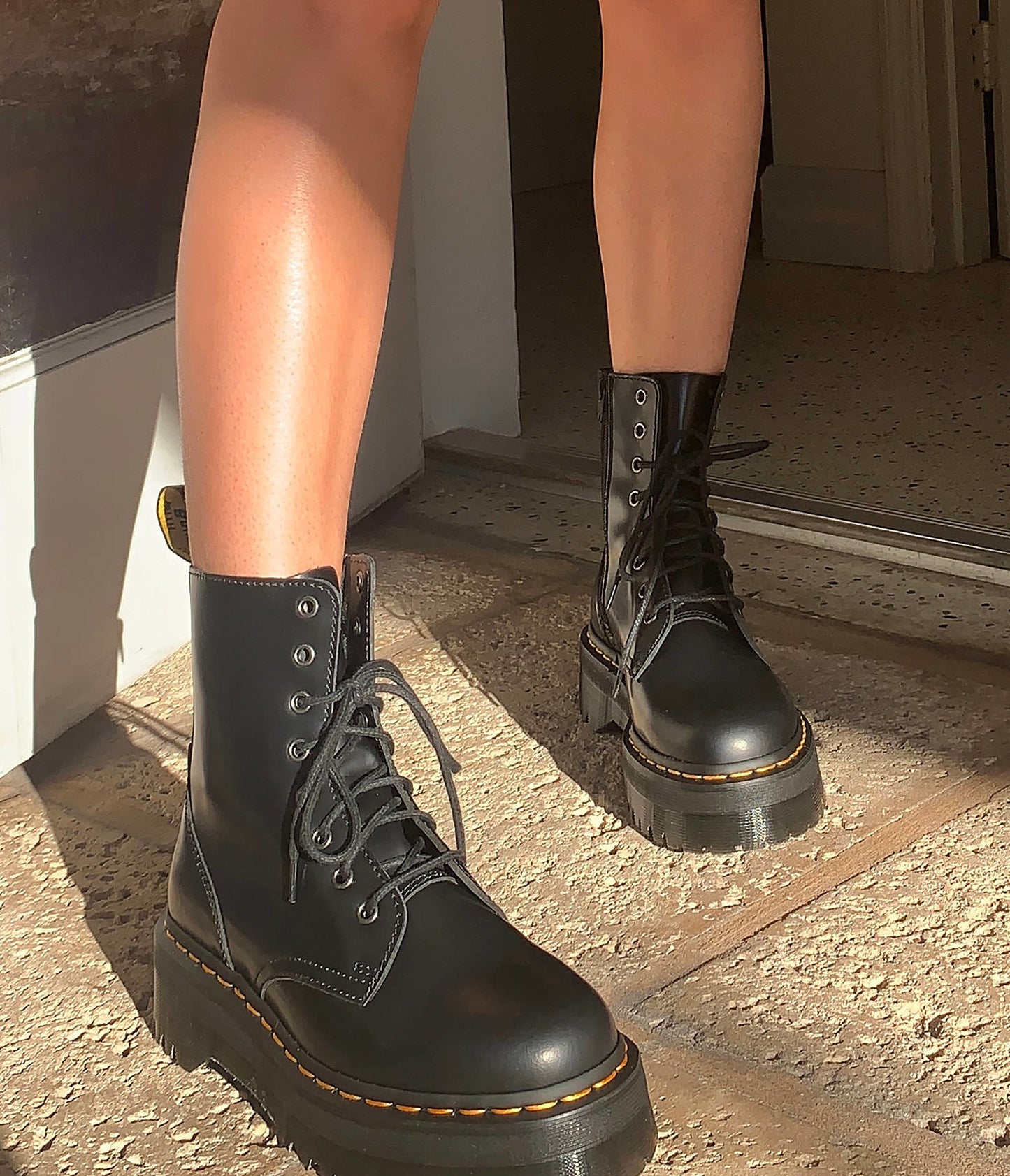 a person wearing a pair of dr. marten platform boots
