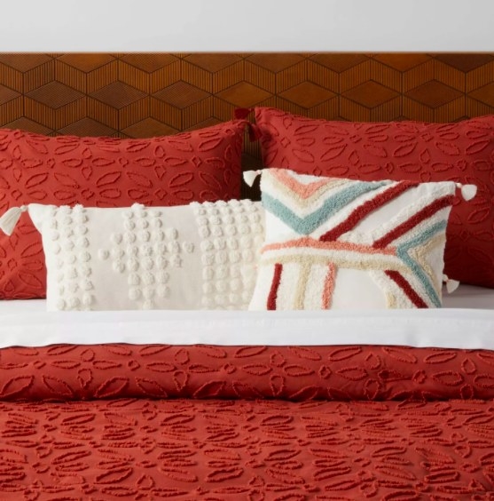 Red, blue, and white pillow on red bed