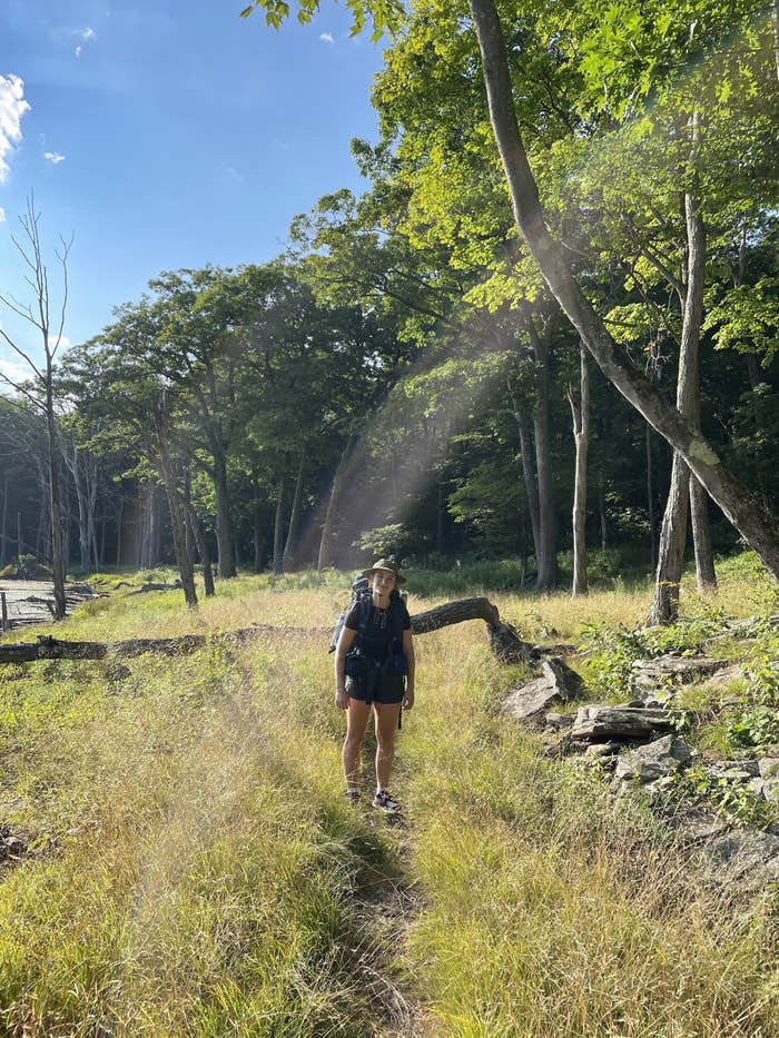 person carrying a backpack in a wooded area