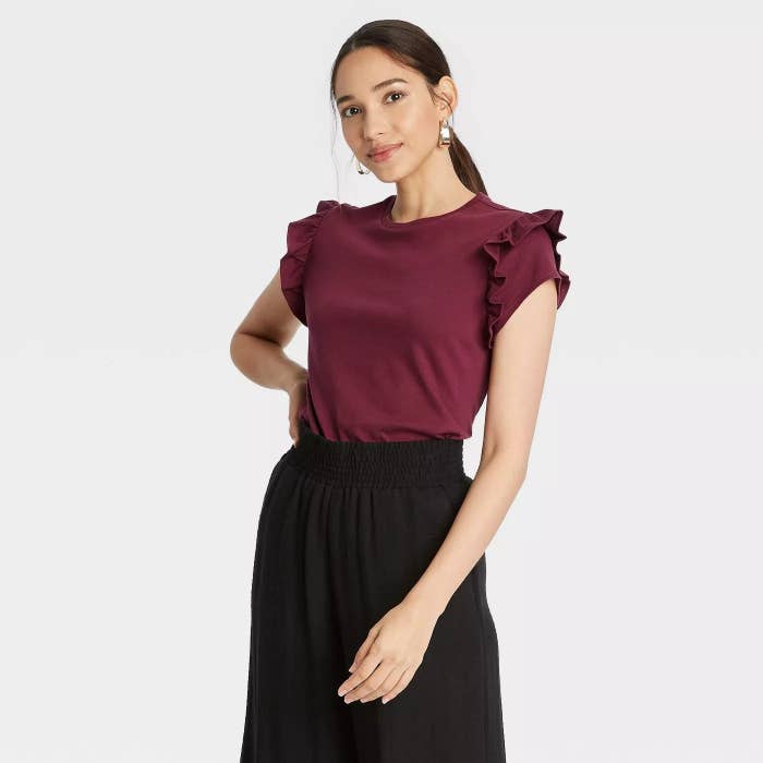 Model wearing burgundy shirt with detailing on the sleeve
