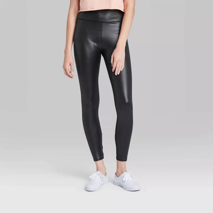 Model wearing high waisted shiny leggings, stops above the ankle