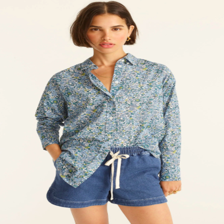 model wearing floral button down with one side tucked into shorts