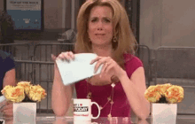 Kristen Wiig ripping a piece of paper and pretending to eat it in an SNL sketch