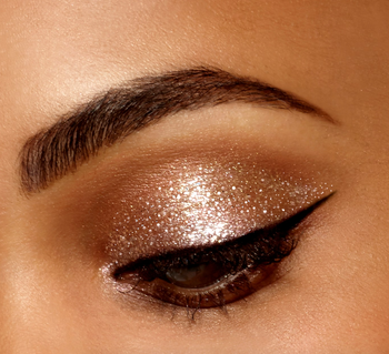 a model with a glittery gold eyelid