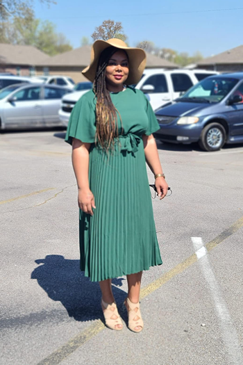 reviewer wearing the dress in green