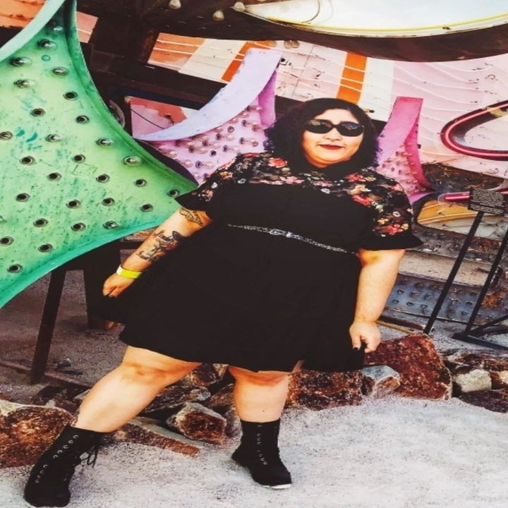 A reviewer wearing the black short sleeve dress with an embroidered floral sheer panel 