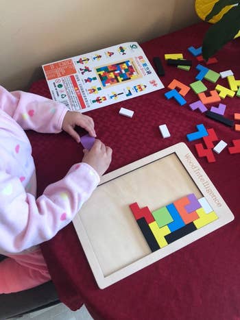 Reviewer's photo showing their child working on the puzzle following a leaflet that shows different diagrams