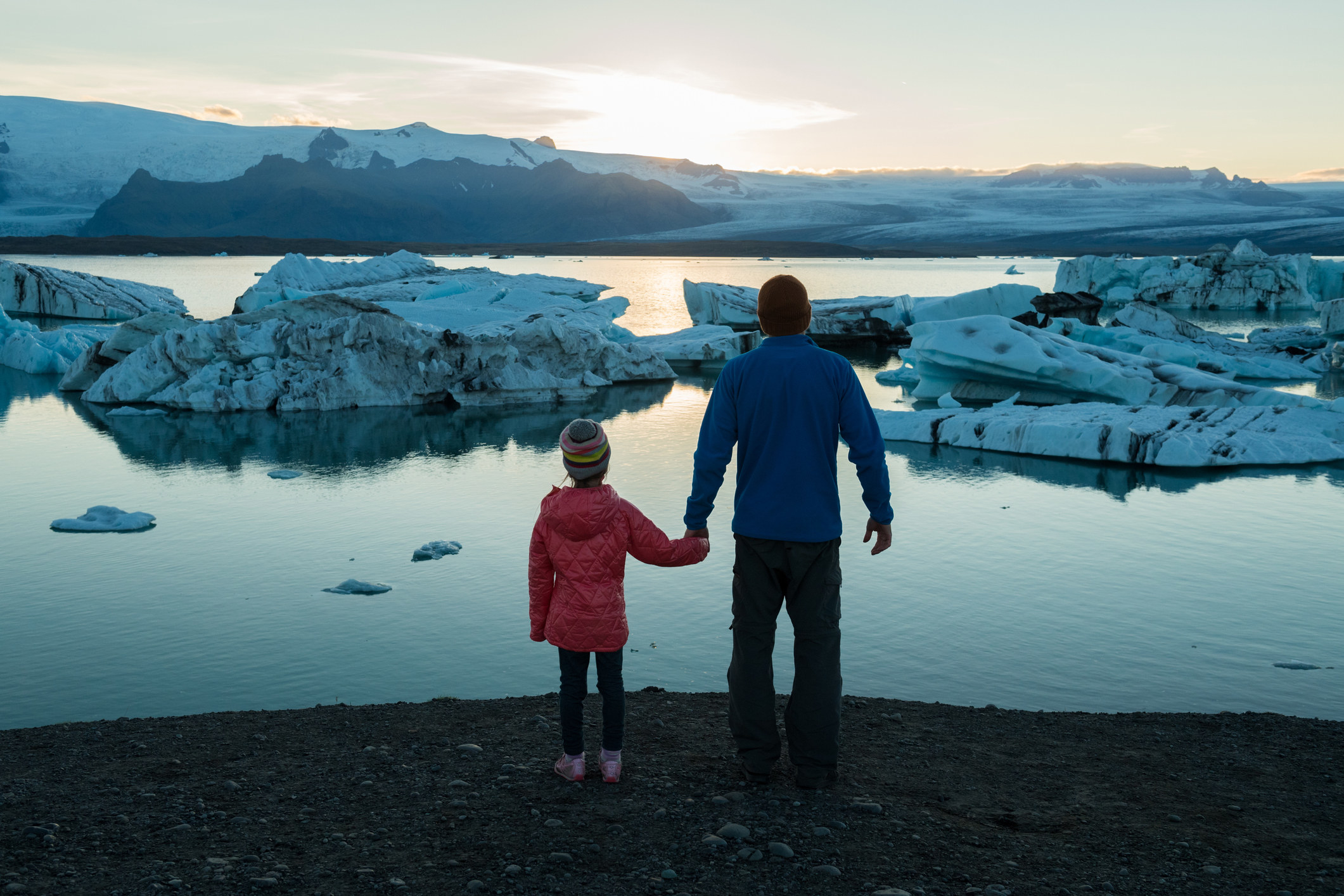 A man and his daughter looking out at glaciers