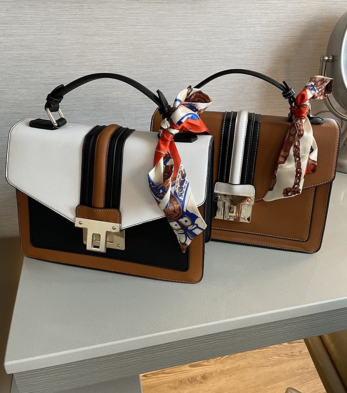 black, white, and brown color blocked bags with printed scarves on handles