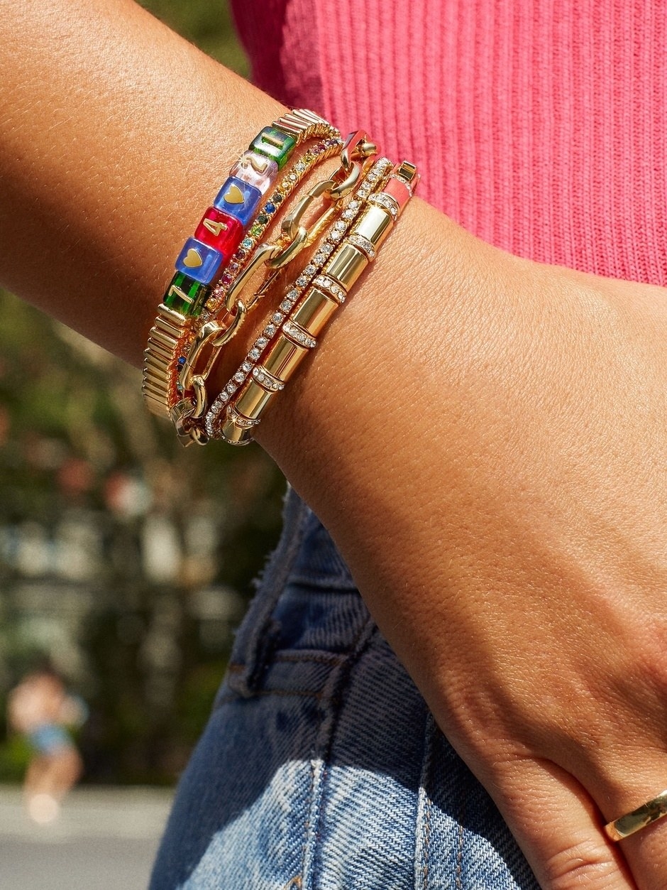 model in gold and colorful stacked bracelets