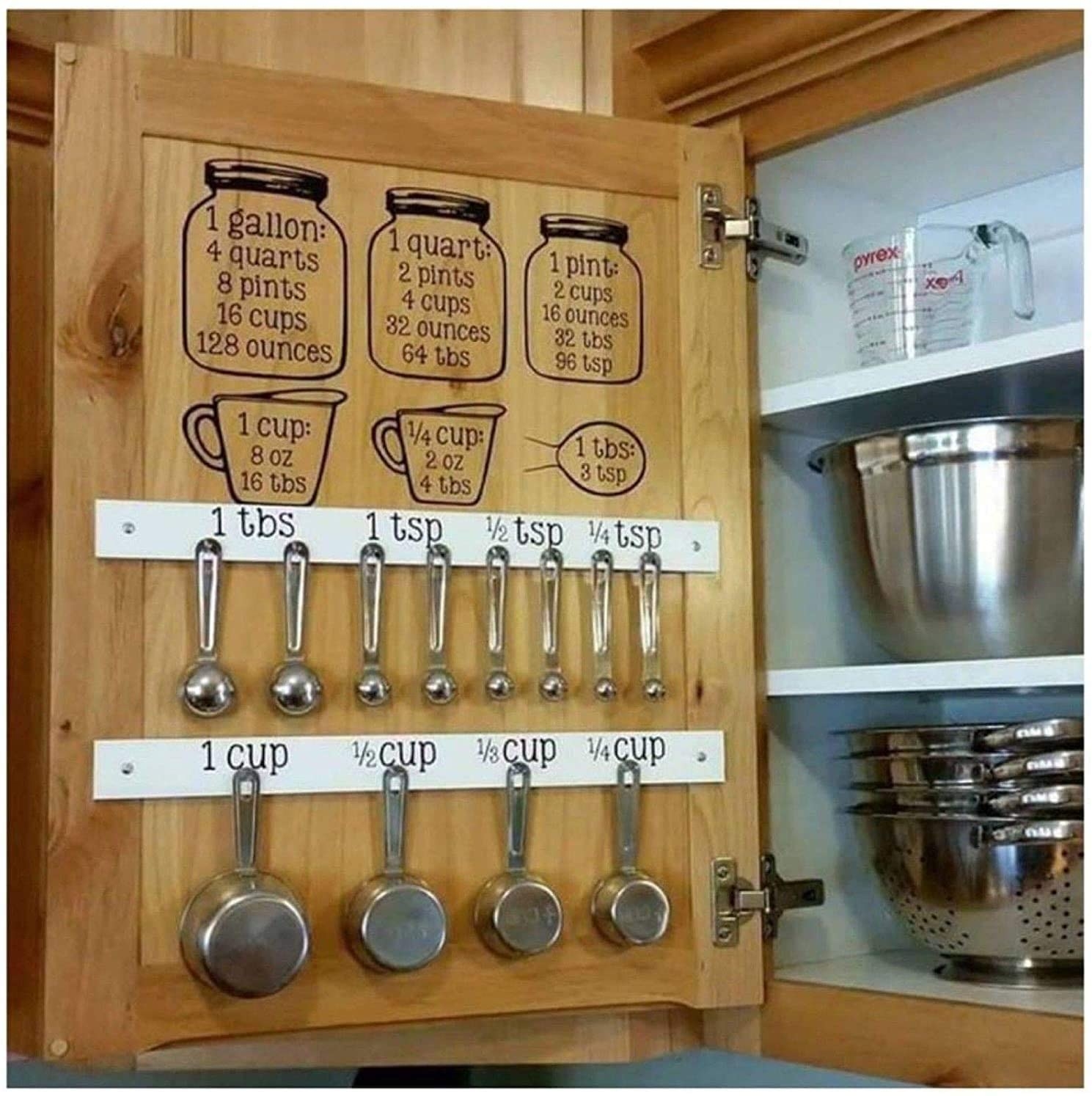 inside of a kitchen cabinet with the decals and measuring cups hanging.