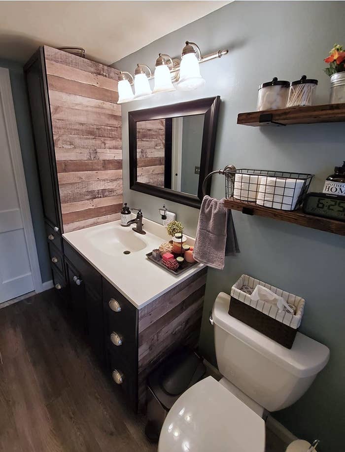 Reviewer&#x27;s bathroom shows the reclaimed wood wallpaper on some parts of the walls