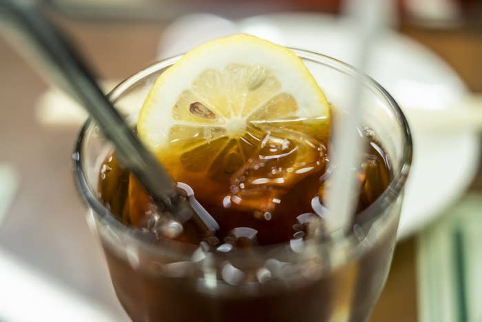 A glass of soda with a lemon slice.