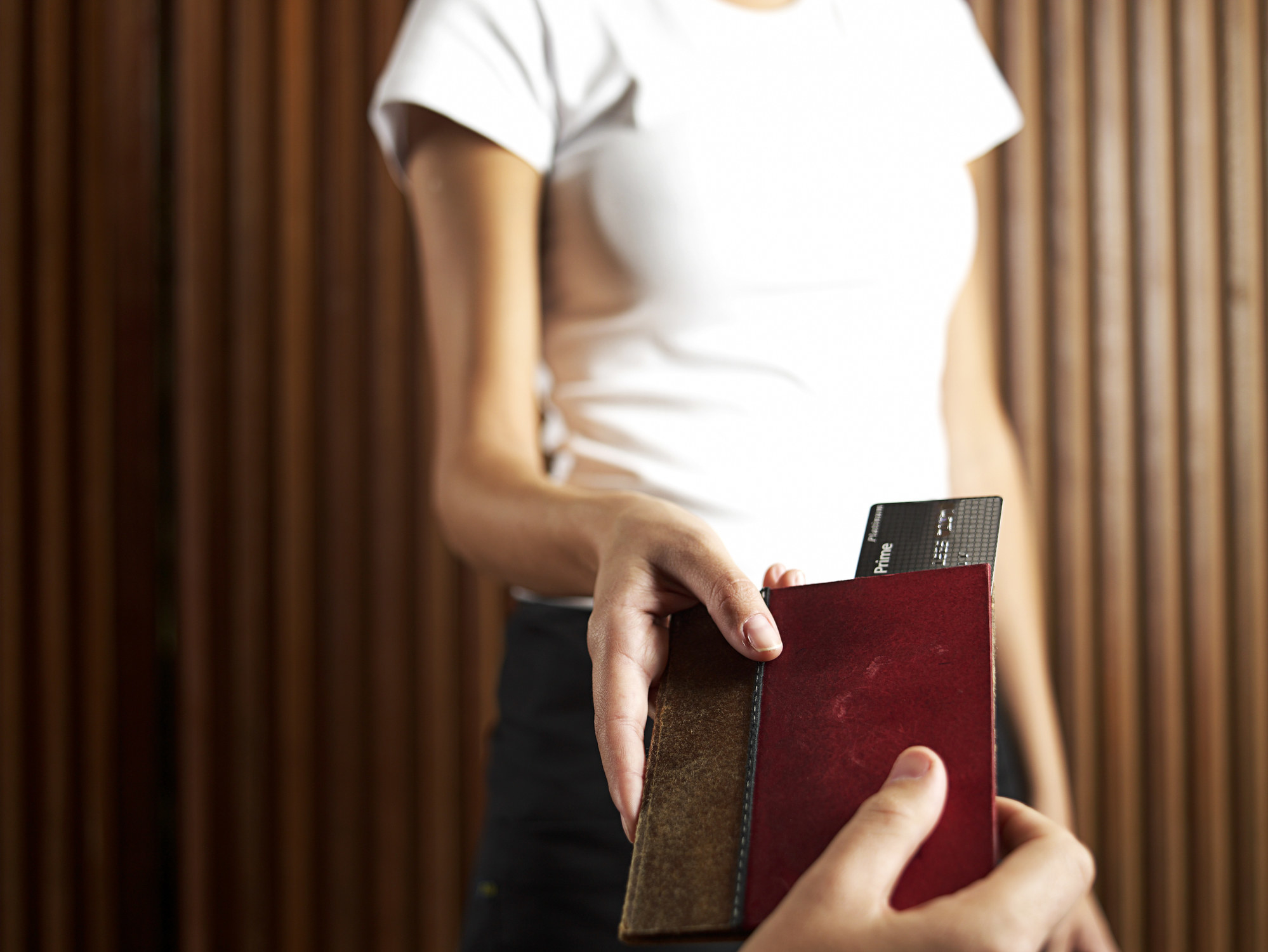 A waiter taking a check with a credit card.