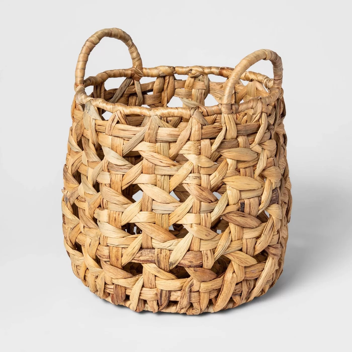 The intricately woven basket has two handles and has different tons of tan and brown throughout