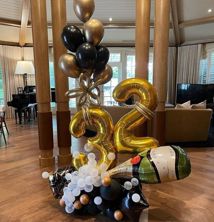Balloons in the shape of a champagne bottle and the number 32 in the middle of Joe's living room