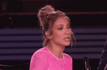 Jennifer Lopez crossing her arms in disappointment