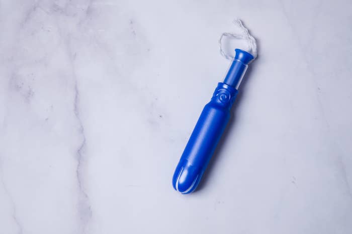 an image of a tampon applicator on a white marble background